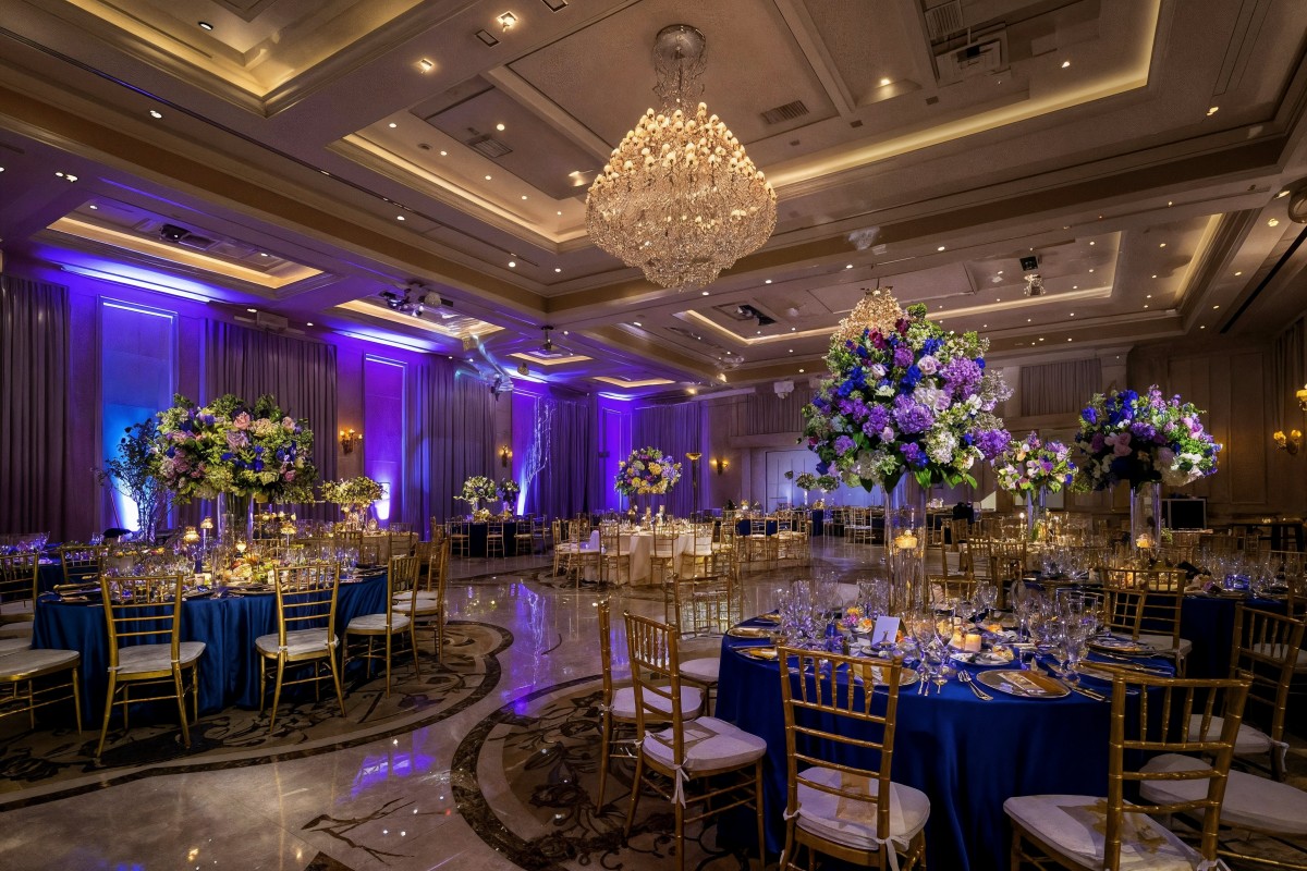 Decorated wedding hall with flowers and chandeliers.